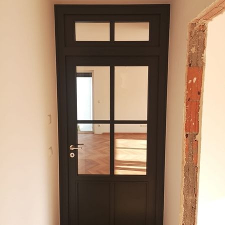 Eine schwarze Tür in einem Raum mit Holzböden