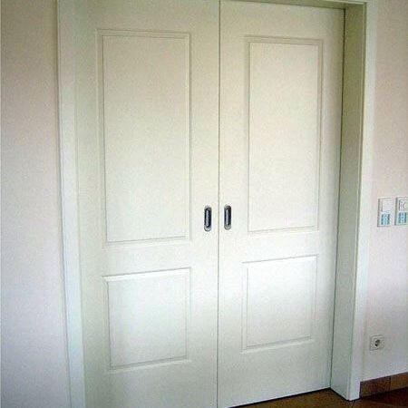 Eine weiße Doppeltür mit zwei Griffen