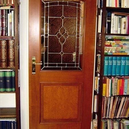 Eine Tür mit Glasfront, vor der sich mehrere Bücherregale befinden