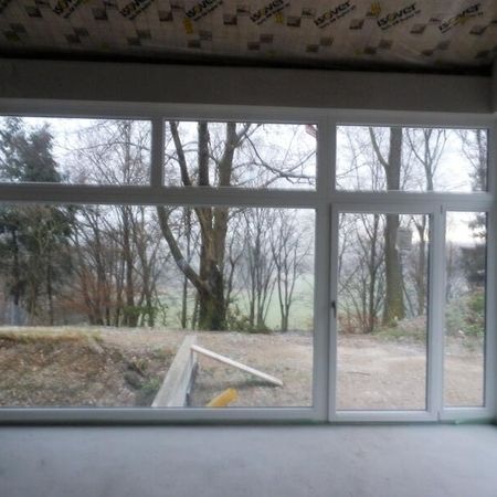 Geräumiger Raum mit großen Fenstern und Blick auf die Landschaft draußen