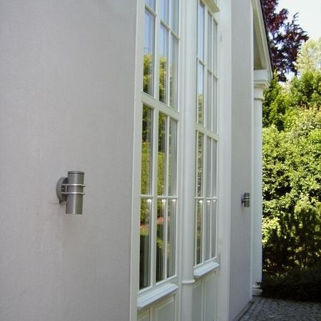 Ein weißes Gebäude mit einem Fenster und einer Lichtquelle an der Wand